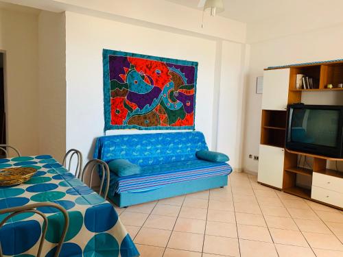sala de estar con sofá azul y TV en Case La Spiaggia, en Sciacca