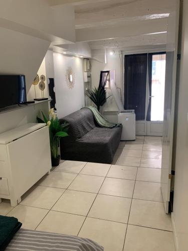 a living room with a couch and a tv at La Garde Studio centre historique, proche plage, climatisation, fibre in La Garde