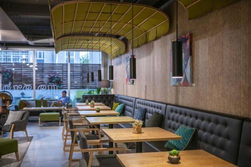 a restaurant with wooden tables and green chairs at ARTIEM Madrid in Madrid