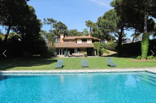 a house with a swimming pool and two lounge chairs at Family Dream in Colares