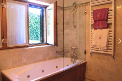 a bathroom with a bath tub and a window at Family Dream in Colares