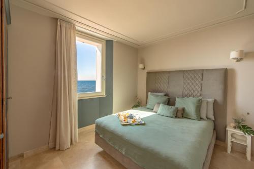 sypialnia z dużym łóżkiem i oknem w obiekcie Antea Apartments w mieście San Vincenzo