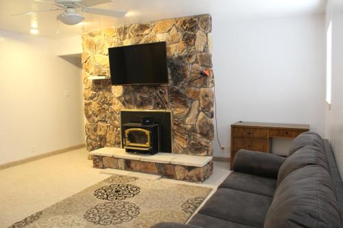 sala de estar con chimenea de piedra y TV en Swallow Cove, en Panaca