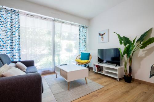 ein Wohnzimmer mit einem Sofa und einem TV in der Unterkunft T2 Port de Vannes in Vannes