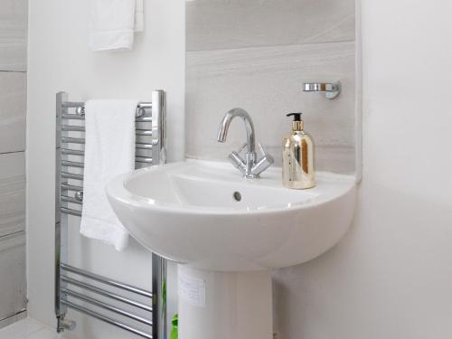 a white bathroom sink with a soap dispenser on it at Sycamore House in Leeds
