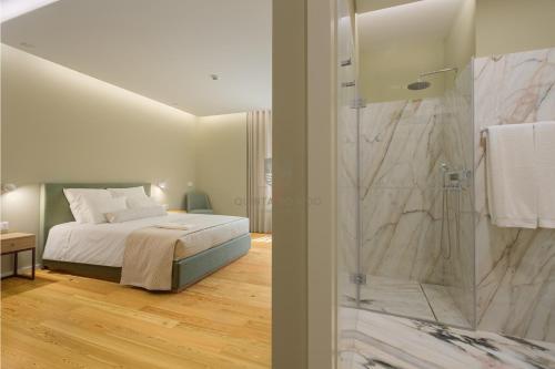 a bedroom with a bed and a glass shower at Quinta do Aido - WineTourism in Cinfães