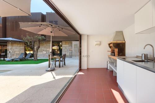a kitchen and dining area with a table and umbrella at Quinta do Aido - WineTourism in Cinfães