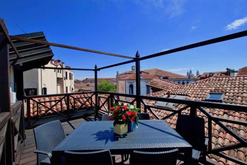 a table with a vase of flowers on a balcony at CA GRIMANI Double Apartment: private terrace and stunning view in Venice