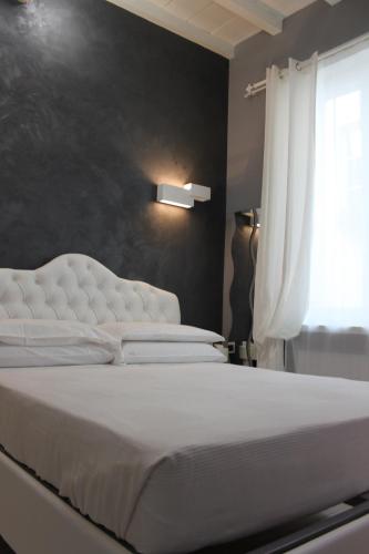 un letto bianco in una camera da letto con finestra di Jacuzzi apartament by parmacentro b&b a Parma