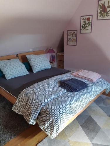 une chambre avec un grand lit avec des oreillers bleus dans l'établissement Le Bukarou, à Saint-Léon-dʼIssigeac