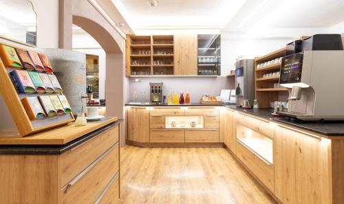 a kitchen with wooden cabinets and a coffee shop at Der Trattner - Hotel Trattnerhof & Hotel Schöcklblick in Semriach