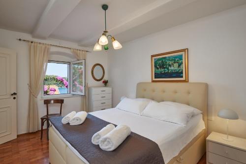 a bedroom with a bed with two towels on it at Villa Magnolia in Cavtat