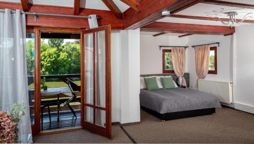 um quarto com uma cama e uma varanda em Éden Lounge Restaurant & Pension em Veresegyház