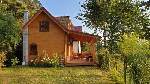 een klein huis met een veranda en een tafel bij Sielski domek Zielony Zakątek in Kętrzyn