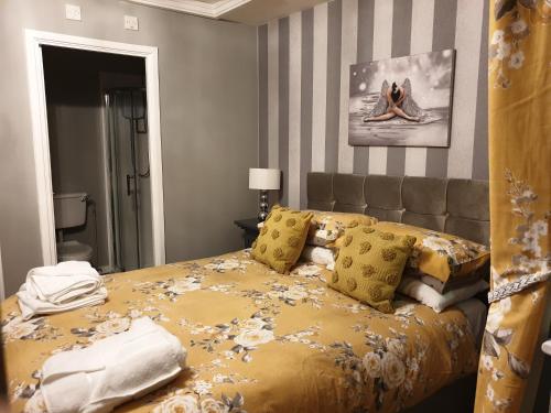 - une chambre avec un lit doté de draps et d'oreillers jaunes dans l'établissement The Harnser, à Stalham