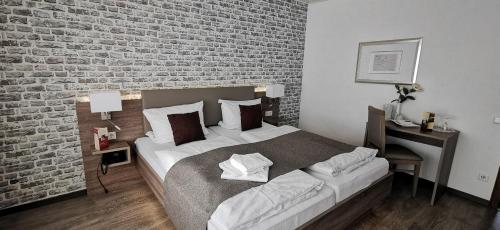 a bedroom with a bed and a brick wall at Hotel-Restaurant Feldkamp 