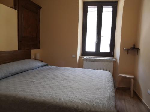 a bedroom with a large bed and a window at Alla Piazza Vecchia in Scanno