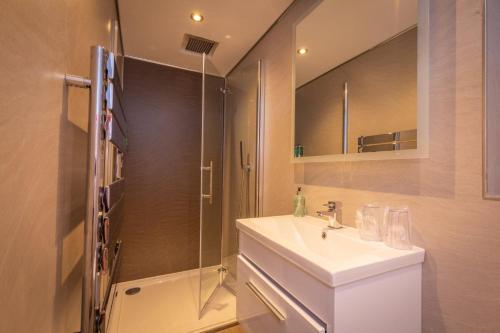 uma casa de banho com um lavatório e um chuveiro em Court Residence Aparthotel em Linlithgow
