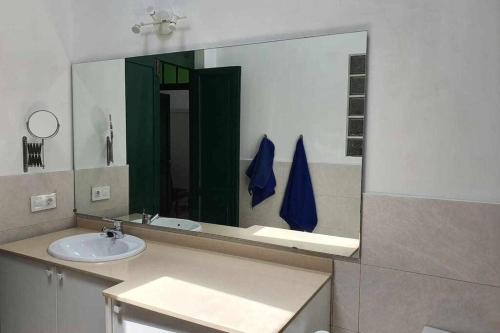 a bathroom with a sink and a large mirror at Casa El Billar in Haría