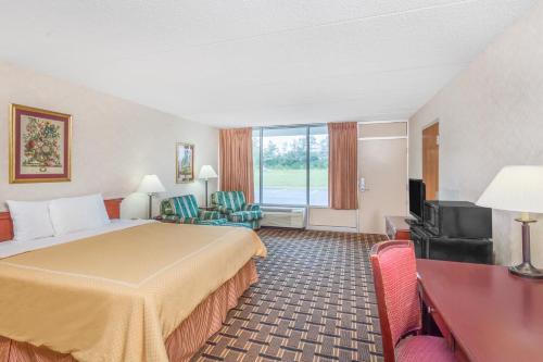 a hotel room with a bed and a television at Relax Inn Greeneville in Greeneville