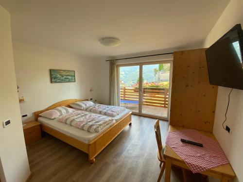 a bedroom with a bed and a large window at Gasthaus St. Valentin in Chiusa