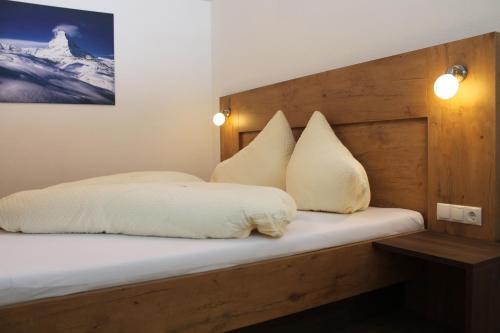 a bed with white sheets and pillows on it at Apart Alpinlive in Ladis