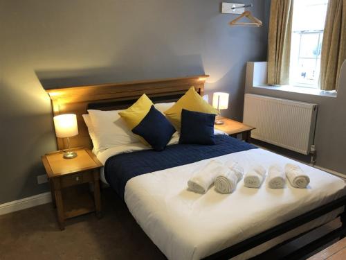 een slaapkamer met een groot bed met 3 kussens bij The White Lion Hotel in Wisbech