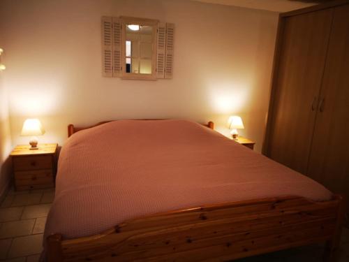 a bedroom with a bed with two lamps on two tables at Résidence Miro, gîtes climatisés avec piscine et tennis in Les Arcs sur Argens
