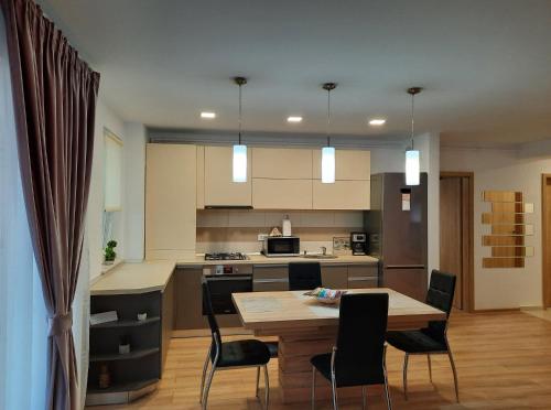 a kitchen and dining room with a table and chairs at Sorin`s Comfortable Apartment in Braşov