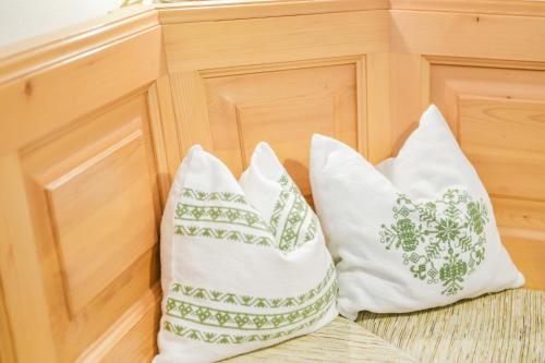 two white pillows sitting next to a wooden cabinet at Beim Kreuzfelder Gambskogel in Inzell