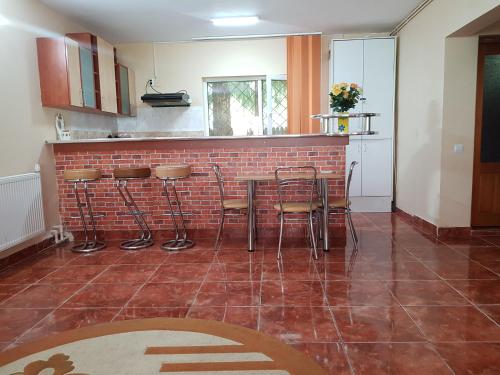 a kitchen with a bar with stools and a brick wall at Vila Andra in Azuga