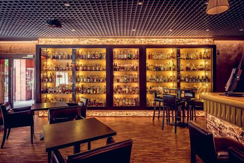 a restaurant with a bar with tables and chairs at City Park Hotel & Residence in Poznań