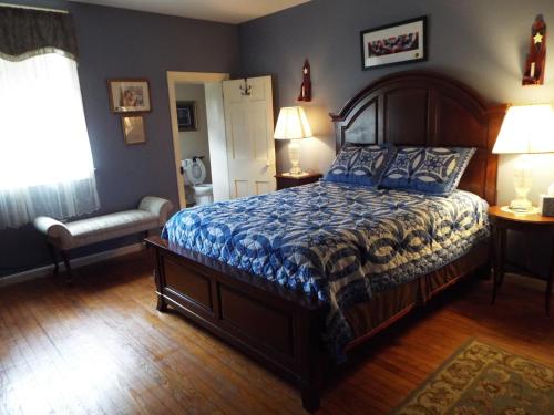 a bedroom with a bed with a blue comforter at The Tillie Pierce House Inn in Gettysburg