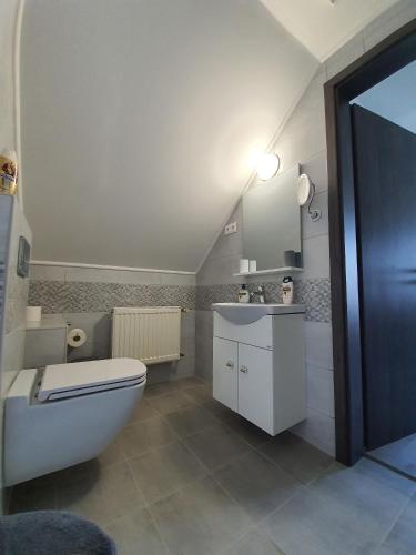 a bathroom with a white toilet and a sink at Monostor Panzió in Komárom