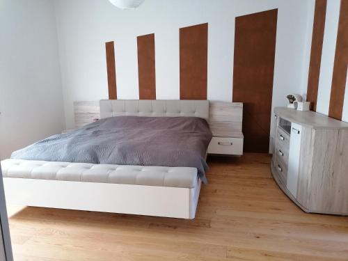 a bedroom with a white bed and a dresser at Ferienhaus am Rand von Berlin - keine Monteursunterkunft in Schönefeld