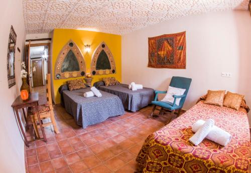 a room with two beds and a table and a chair at Apartamentos La Suerte in Hinojares