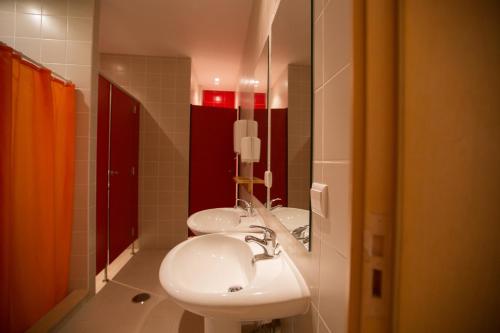 a bathroom with two sinks and a mirror at HI Tavira – Pousada de Juventude in Tavira