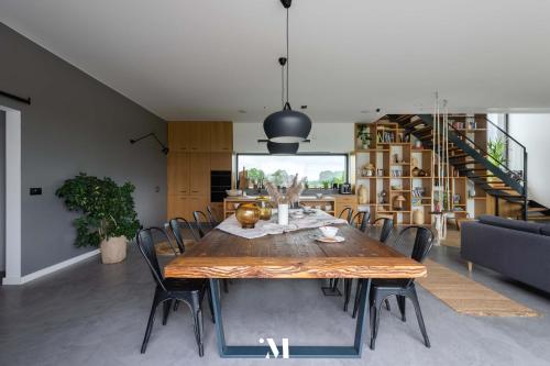 a dining room with a wooden table and chairs at Punkt Mazury in Sędki