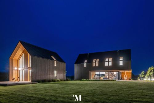 a barn house with a black roof at night at Punkt Mazury in Sędki