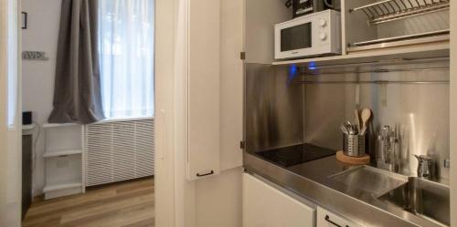 eine Küche mit einer Spüle und einer Mikrowelle in der Unterkunft Madonnina Apartment in Mailand