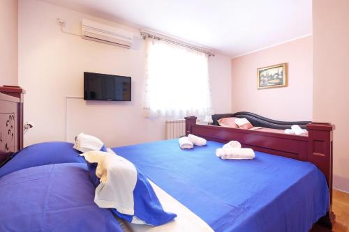 a bedroom with a blue bed with towels on it at Villa Tower Gardos in Belgrade