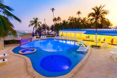a large swimming pool in a resort with palm trees at Hotel Dann Cartagena in Cartagena de Indias