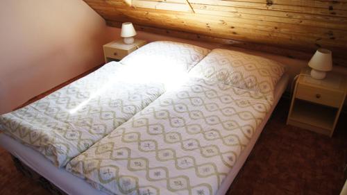 a bed in a room with two night stands and two lamps at Pension Kalista in Klatovy