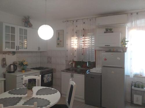 a kitchen with a table and a kitchen with white appliances at Stella in Split