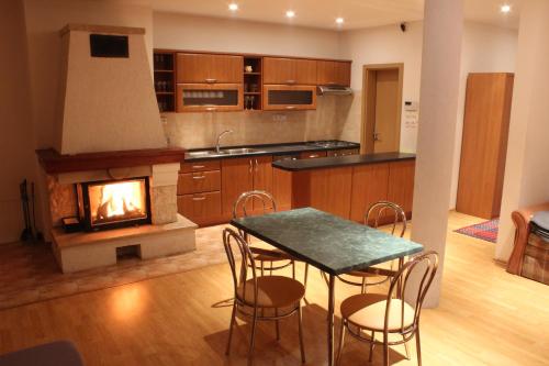 a kitchen with a table and chairs and a fireplace at Apartmán TRIGA in Snina