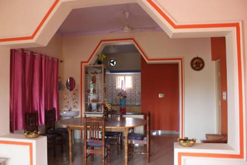 uma sala de jantar e cozinha com mesa e cadeiras em Comfort Zone Homestay em Madikeri