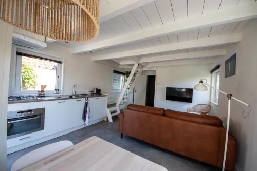 uma sala de estar com um sofá e uma cozinha em BeachWay em Nes