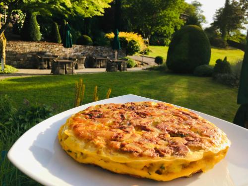 a pizza sitting on a white plate on a table at Hotel Schlossberg in Badenweiler