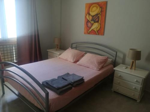 a bedroom with a bed with two tables and a painting at Apartamento Markinca in Vilamoura