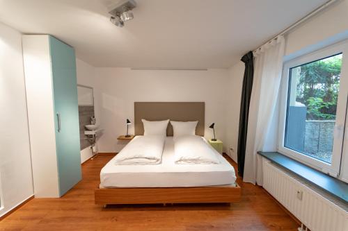 a bedroom with a bed and a large window at The Suites City Apartments in Hamburg